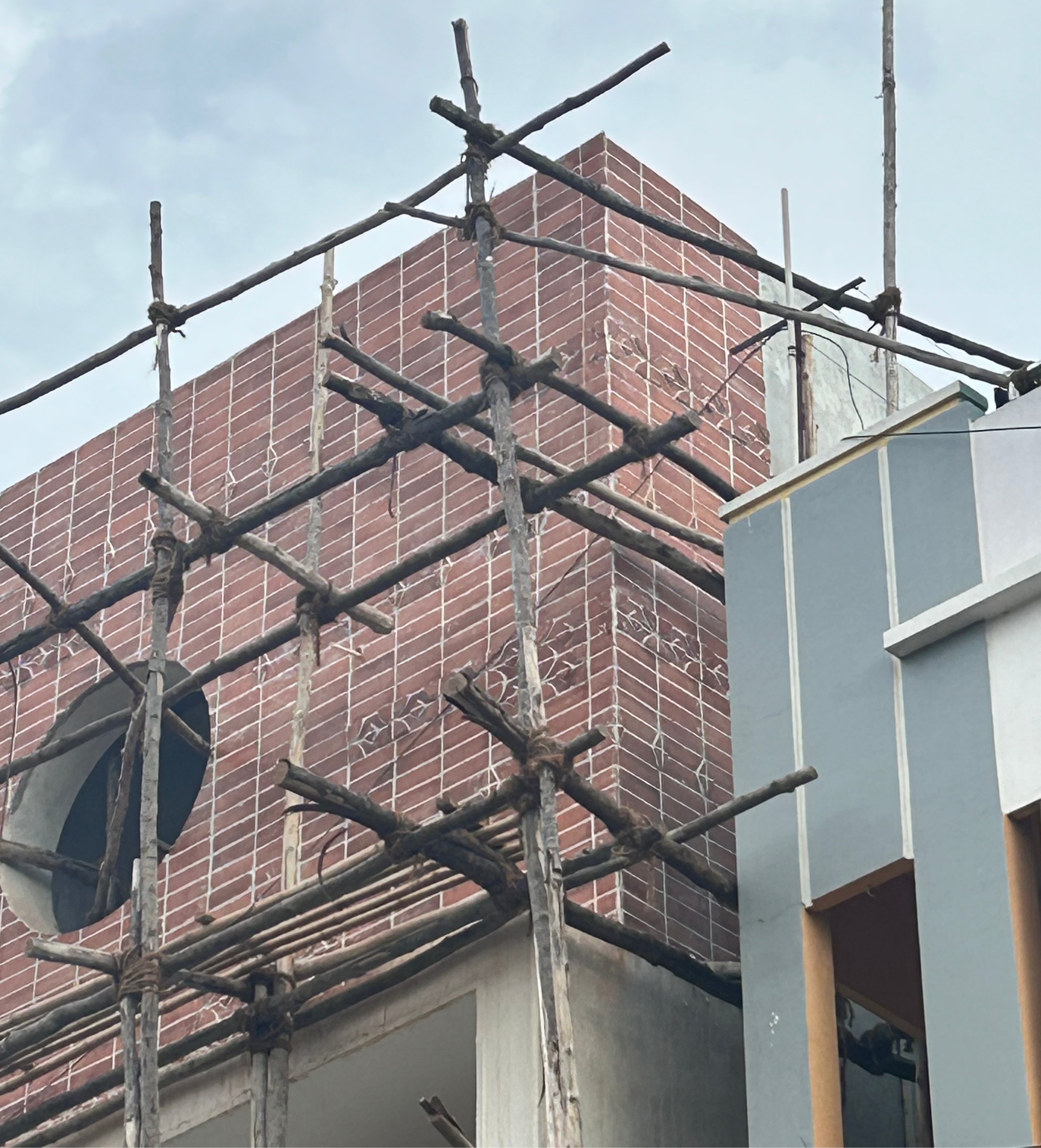 Scaffolding on a building with a brick facade and clear sky.